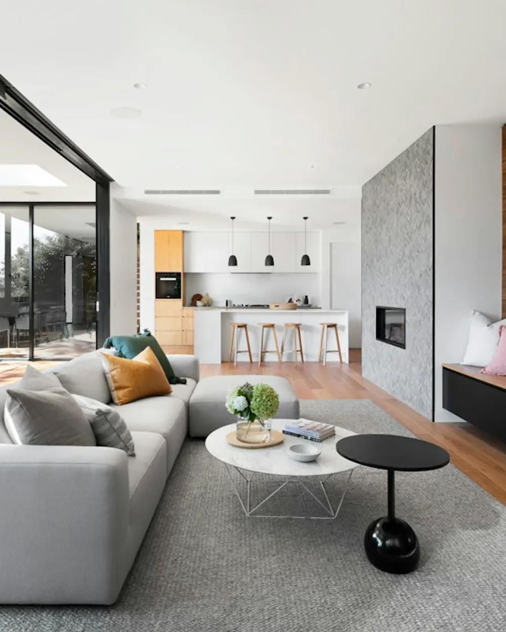 Bright modern living room opening onto a kitchen and dining space.