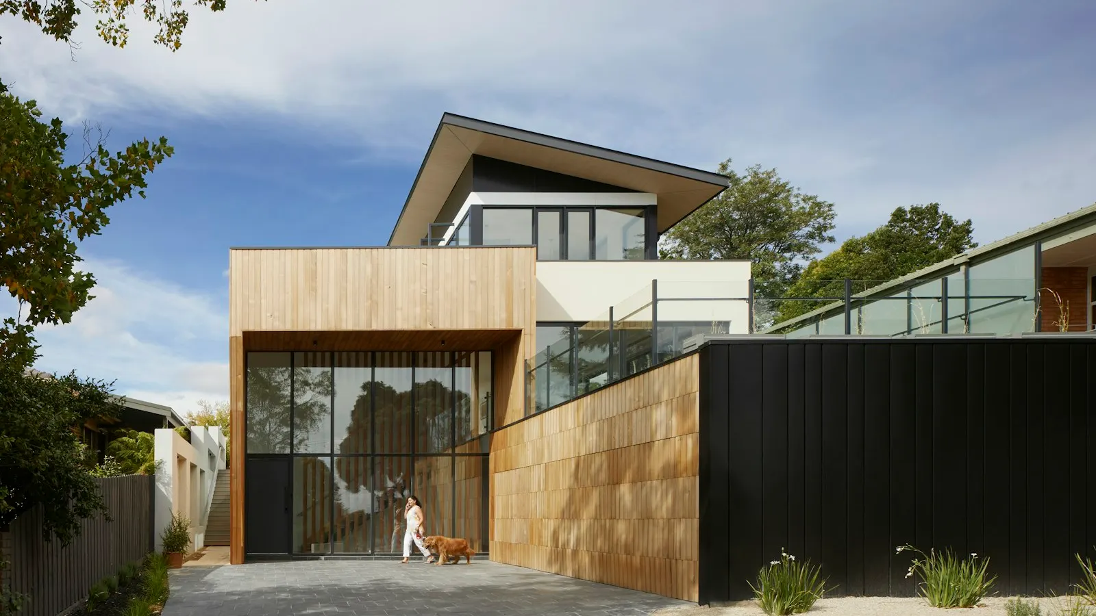 Modern home exterior with large windows and natural wood finishes.